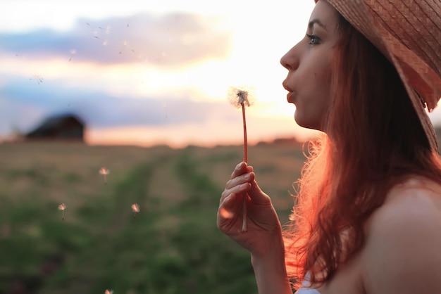 Foto garota de verão do sol em um campo com flores