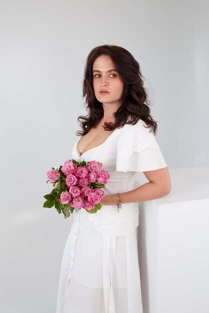 Garota de vestido branco com um buquê de flores