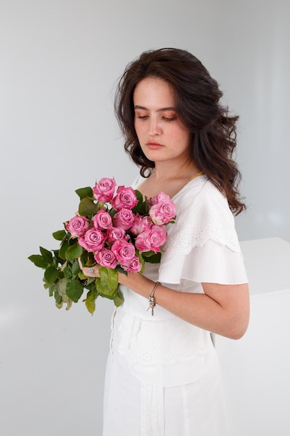 Garota de vestido branco com um buquê de flores