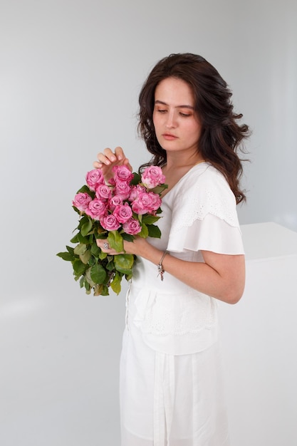 Garota de vestido branco com um buquê de flores