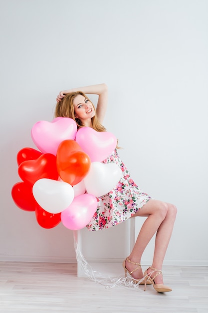 Garota de vestido romântico com balões em forma de coração