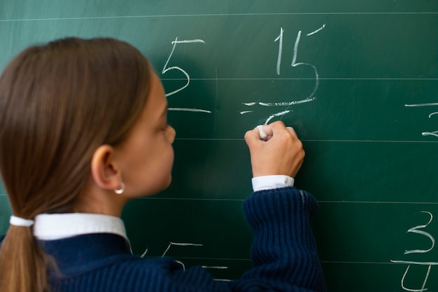 Foto garota de vista traseira aprendendo matemática na escola