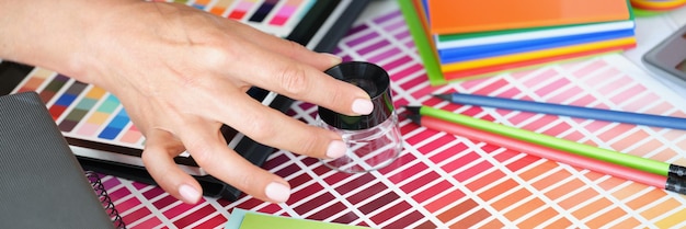 Garota designer olhando através da lupa para a paleta de cores