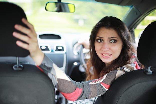 Garota dirigindo um carro com emoções ruins em seu rosto