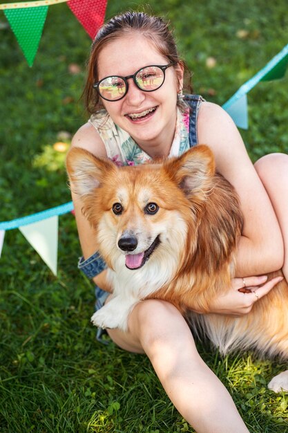 Garota divertida e cachorro em uma grama no parque