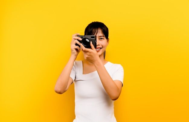 Garota do fotógrafo tirando fotos Modelo isolado em fundo amarelo com espaço de cópia
