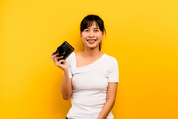 Garota do fotógrafo tirando fotos Modelo isolado em fundo amarelo com espaço de cópia