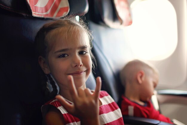 Garota em um avião fazendo símbolo de rock