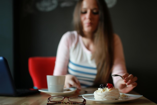 Garota em um café tomando uma xícara de café com o notebook