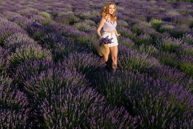 Garota em um campo de lavanda Mulher em um campo de flores de lavanda ao pôr do sol em um vestido branco França Provence