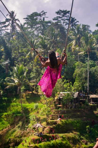 Garota em um grande balanço nos campos de arroz em bali