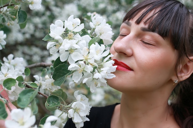 Garota em um jardim de flores de maçã em um dia ensolarado