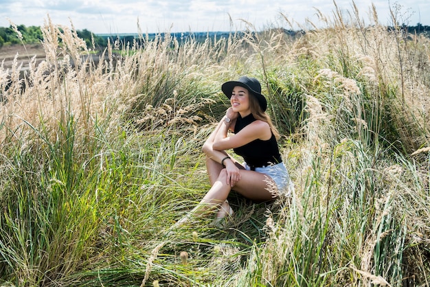 Garota em um pano casual em um campo verde rural vai no verão. estilo de vida