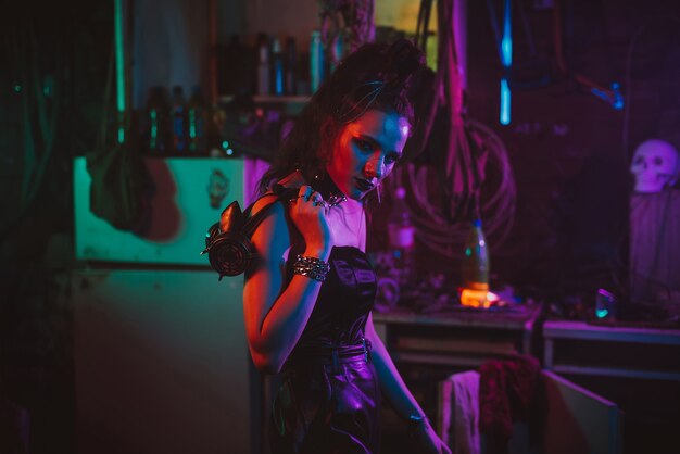 Garota em um terno cyberpunk com uma luz de néon na garagem. Cosplay Steampunk no estilo pós-apocalíptico