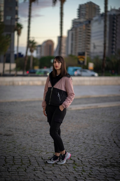 Garota em uma cidade em uma tarde de inverno. Menina vestida com roupas urbanas.