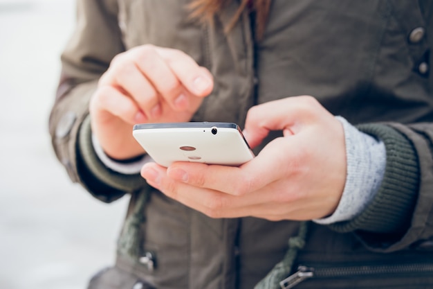 Garota em uma jaqueta verde usa um smartphone enquanto caminhava no fundo do mar