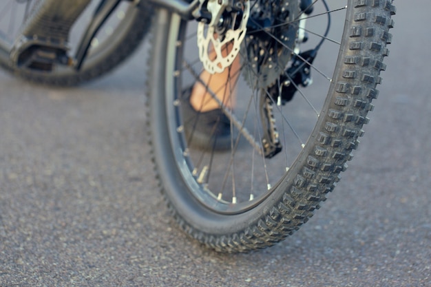 Garota em uma mountain bike no offroad, belo retrato de um ciclista, Fitness girl monta uma moderna mountain bike de fibra de carbono em roupas esportivas.