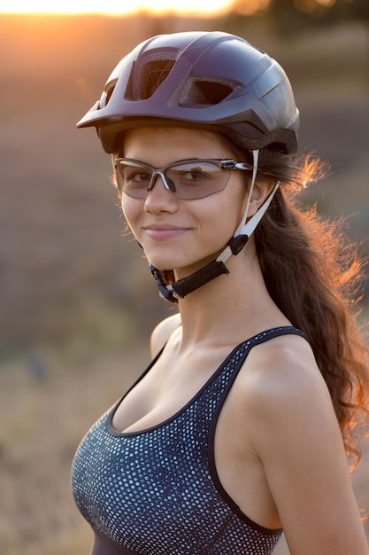 Garota em uma mountain bike no offroad lindo retrato de um ciclista ao pôr do sol Garota fitness cavalga