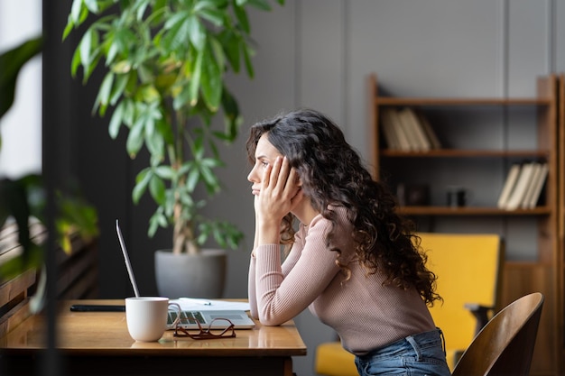 Garota entediada, cansada de aprender online, olha para o laptop preguiçoso freelancer frustrado com a tarefa