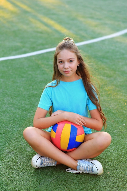 Foto garota esportiva com uma bola no campo de futebol