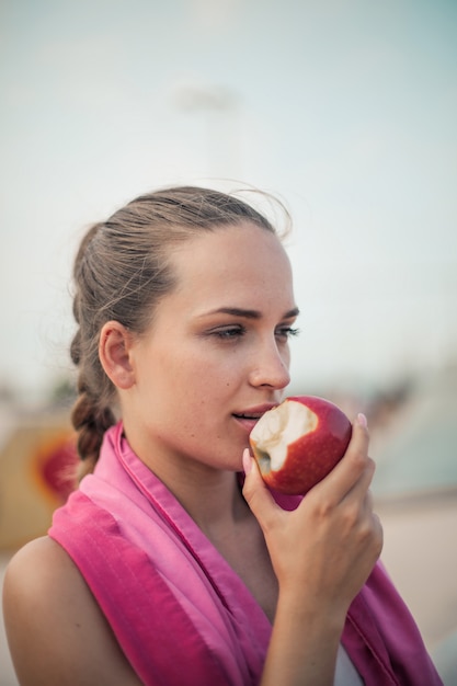 Garota esportiva comendo maçã