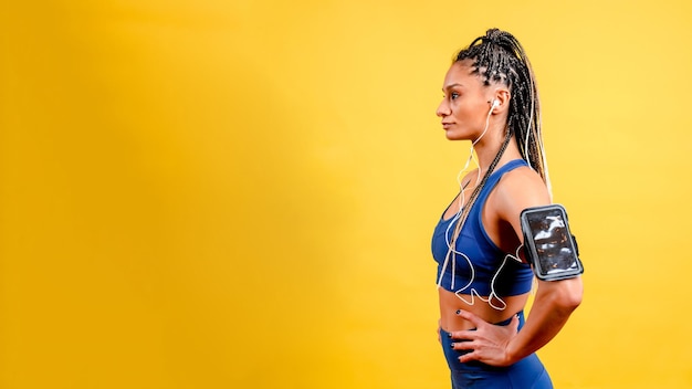 Foto garota esportiva fazendo exercícios, em um fundo amarelo