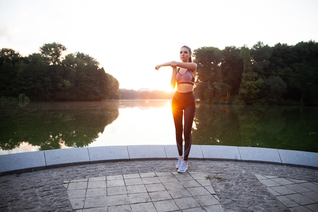 Foto garota esportiva fitness em roupas esportivas da moda fazendo exercícios físicos na rua, esportes ao ar livre, estilo urbano