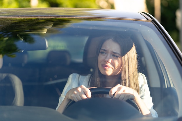 Garota estressada dirige seu carro pela primeira vez tenta evitar um acidente de carro muito nervosa e assustada