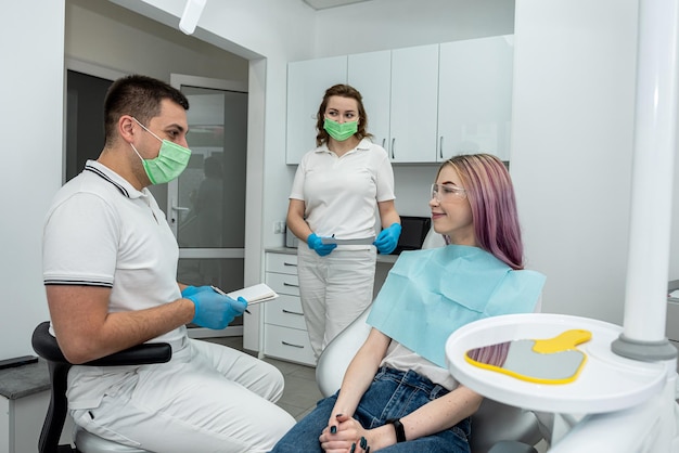 garota falando consultando com um dentista e assistente caucasiano jovem mulher se sente feliz em receber cuidados de um dentista profissional para a cárie dentária doença da gengiva em um programa de cuidados dentários odontologia