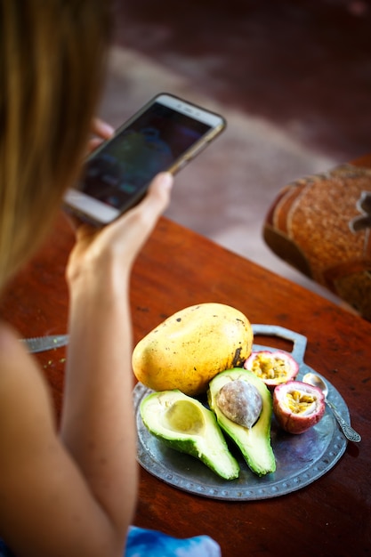 Garota faz foto em smartphone de frutas exóticas