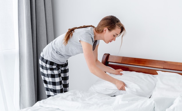 Foto garota fazendo a cama