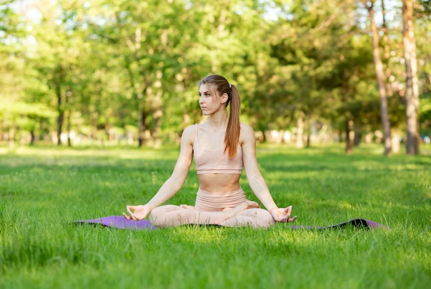 Garota fazendo alongamento exercícios ao ar livre. praticando ioga jovem
