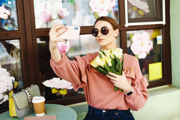 Garota fazendo selfie com tulipas