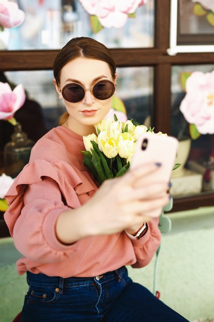 Garota fazendo selfie com tulipas