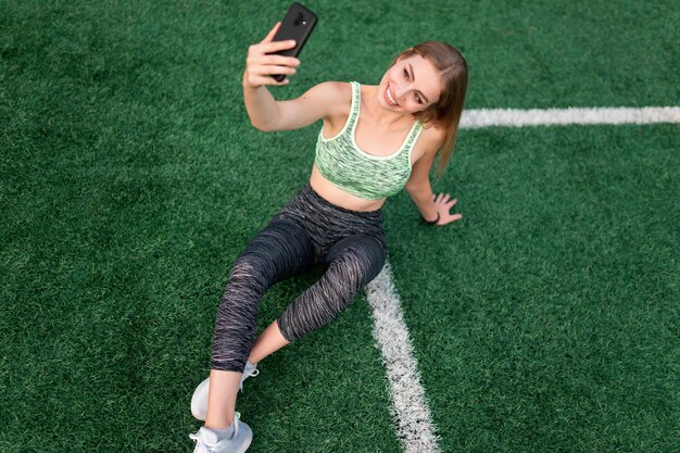 Garota fazendo selfie no gramado