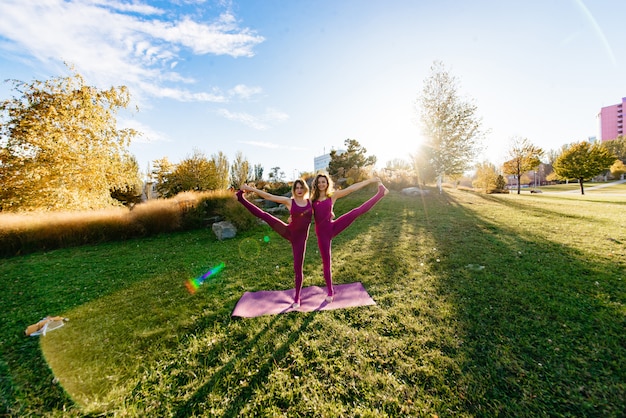 Garota fazendo yoga no parque, relaxando e meditando enquanto estiver rodeado pela natureza.