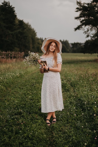 Garota feliz Cabelo comprido Vestido branco Um chapéu com aba