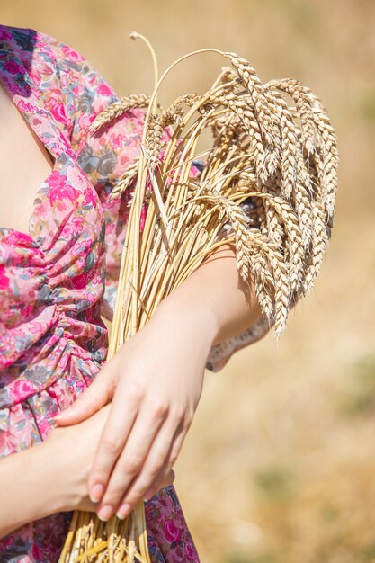 Garota feliz com chapéu no campo de trigo. Chapéu grande e cabelo comprido esvoaçante