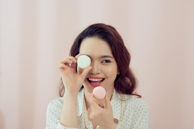 Garota feliz com macaron no fundo rosa