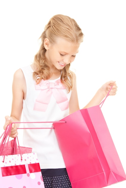 Foto garota feliz com sacolas de compras sobre branco