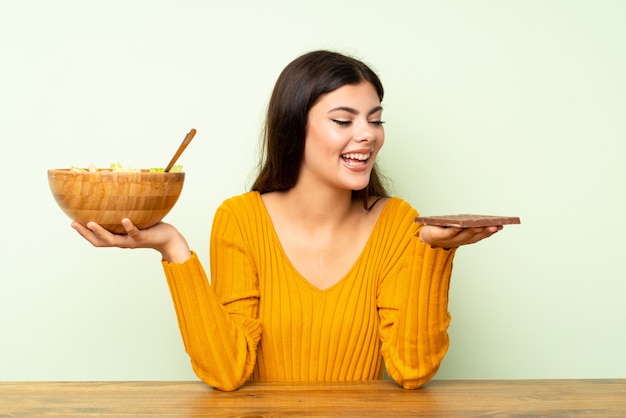 Garota feliz com salada e chocolate