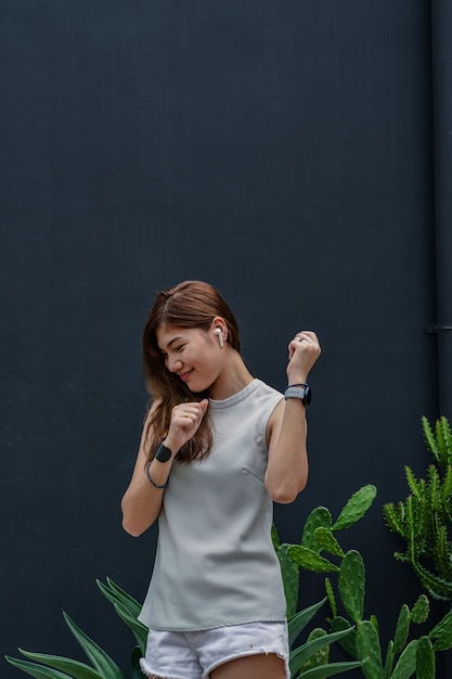 Garota feliz curtindo música em airpods e dançando a música favorita, viagem relaxante para fora.