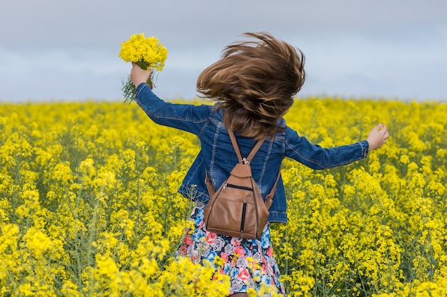 Foto garota feliz em florescendo campo amarelo com estupro