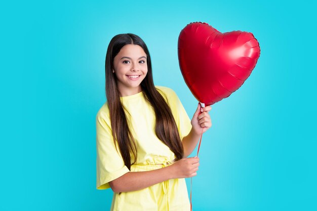 Garota feliz enfrenta emoções positivas e sorridentes Retrato de criança adolescente com balão de coração Conceito de dia dos namorados Rosto animado emoções alegres de adolescente