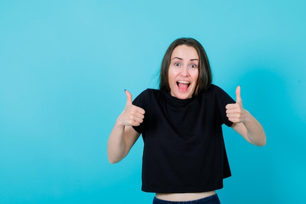 Garota feliz está mostrando gestos perfeitos sobre fundo azul