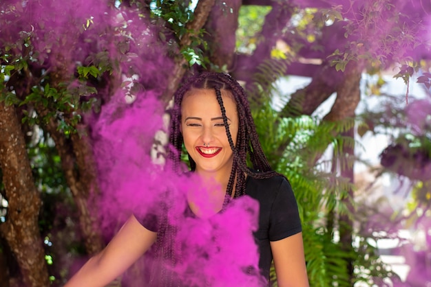 Garota feliz, linda garota feliz com bastão de fumaça colorida com luz natural