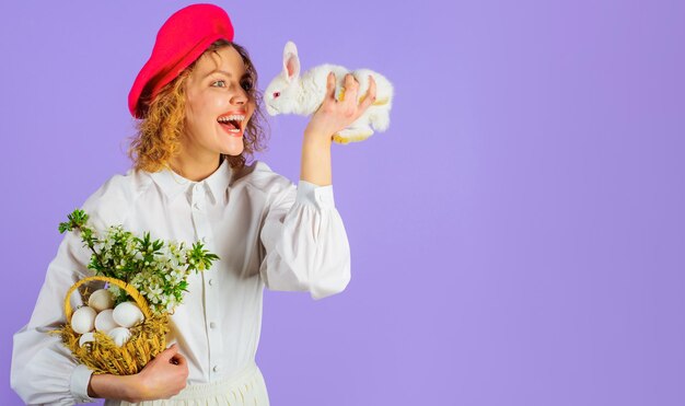 Garota feliz na boina com ovos de cesta e acessório de dia de páscoa de coelhinho pequeno para mulher estilo francês