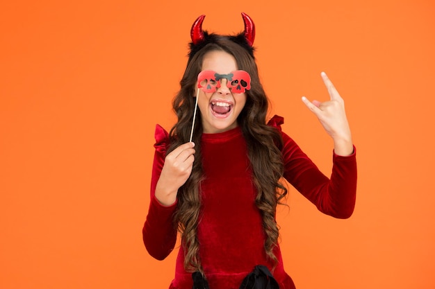 Garota feliz no Halloween usa fantasia de carnaval engraçada e óculos internos com aparência assustadora, truque ou travessura