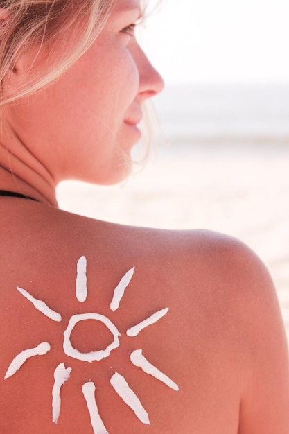 Foto garota feliz no ombro do sol na praia no verão na natureza