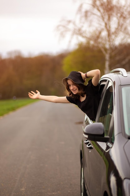 Foto garota feliz olha pela janela do carro em um dia de verão